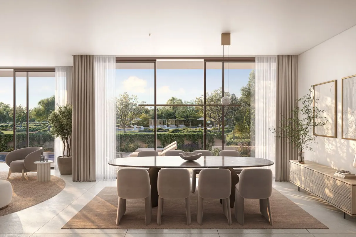 Dining table set before full-height windows facing greenery